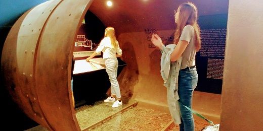 2 chicas haciendo actividades interactivas en el Museu del ciment, se ve también un perro, ya que es un museo pet friendly.