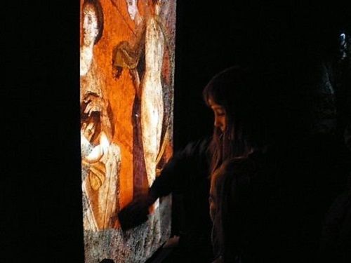 Niña interaccionando con pantalla en el museo virtual de Herculano
