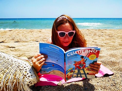 Chica en la playa con el cuaderno de vacaciones para adultos