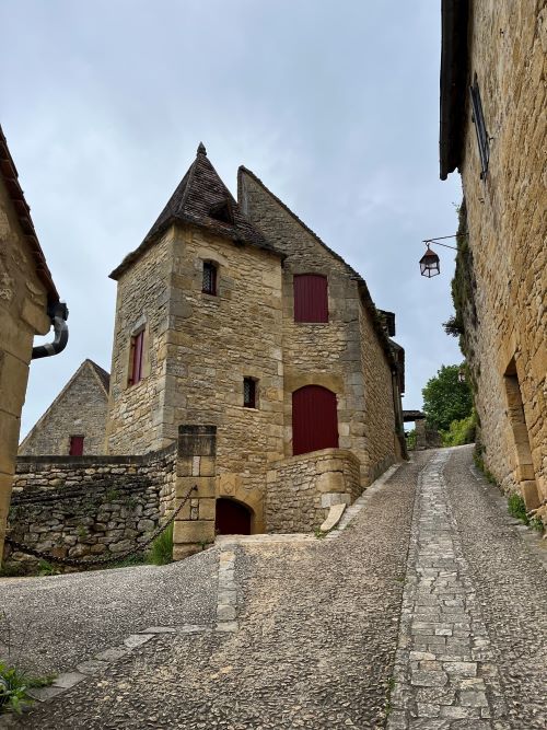 Calle empedrada del pueblo, con los tejados de piedra típica de la Dordoña.