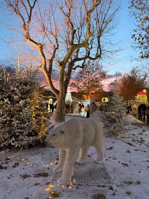 Bosque de Navidad en Béziers, sur de Francia, al atardecer con las luces navideñas recien encendidas. se ve un oso polar y un paisaje nevado